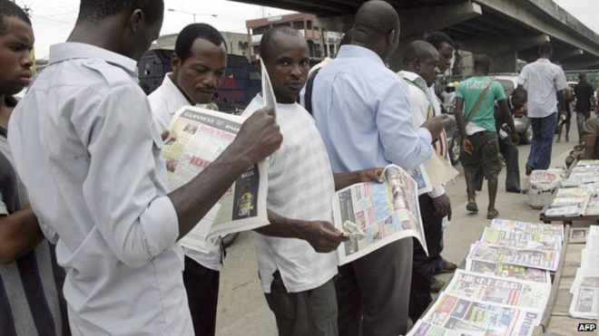 Nigerian men reading newspapers - Lagos public vehicles